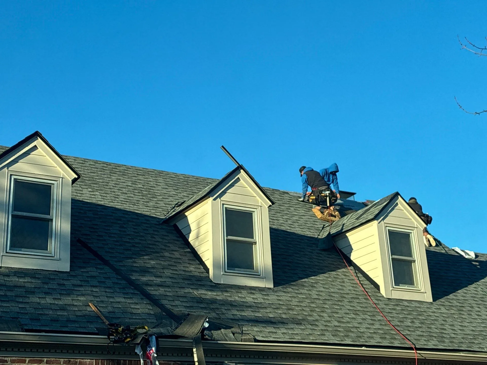 Roofers repairing shingles around dormers on a Waco, KY home.