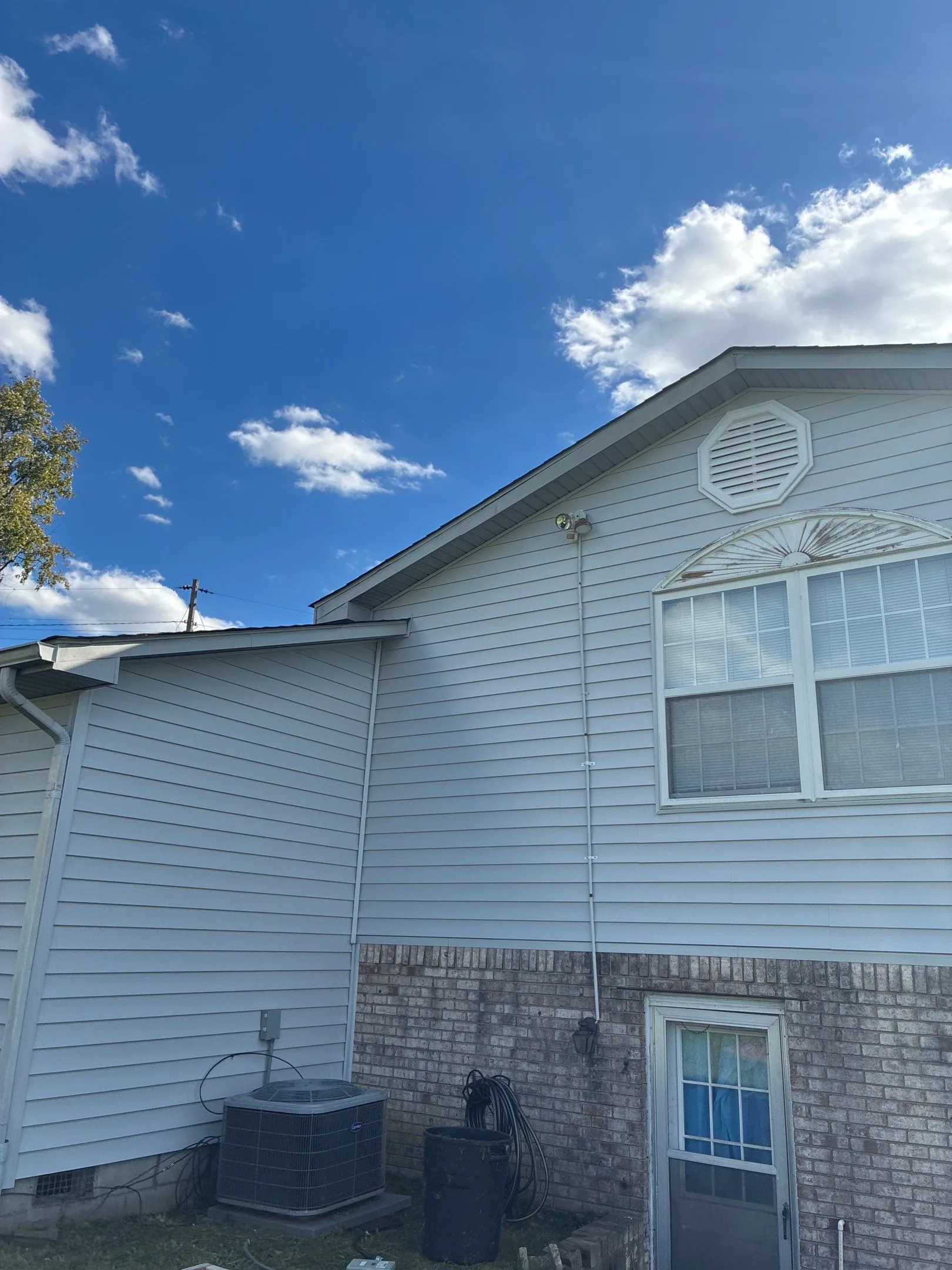 White vinyl siding with a decorative gable vent and arched window on a Waco, KY home.